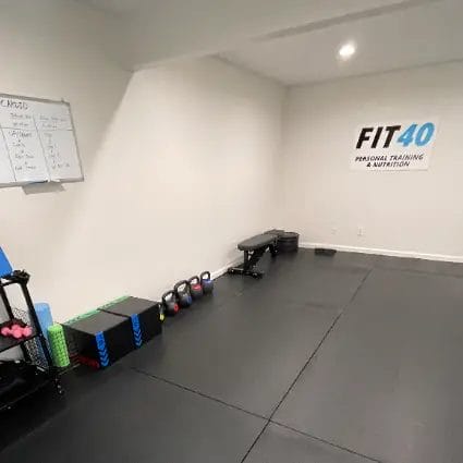 Interior of FIT40 Personal Training studio with training bench, kettlebells, and functional workout equipment